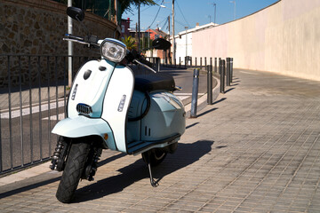 Moto Scooter italiana tipo scooter o aparcada en ciudad mediterránea, Barcelona, con asfalto y acera.