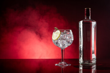 Gin tonic on red background with smoke with copyspace.