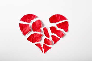Pieces of crumpled and torn red heart shape paper isolated on white background paper. Broken heart concept.