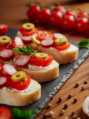 Fototapeta na wymiar Bruschetta with tomatoes, mozzarella cheese and basil on a cutting board. Traditional italian appetizer or snack, antipasto. Top view with copy space. 