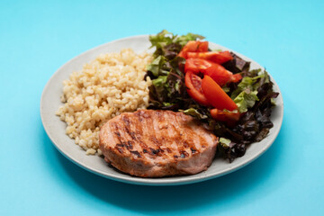 grilled meat hamburger with boiled rice and salad on white dish