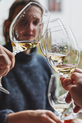 hands Clinking glasses with white wine and toasting in restaurant