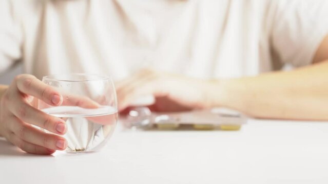 Woman showing a pill and take it. Food supplement oil filled. Capsules with omega 3, fish oil.