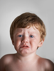 Sad toddler, anxiety and portrait of baby in his home with emotional problem or loss in childhood. Crying, trouble and house with a frustrated young male kid, infant or boy with tears, fear or crisis