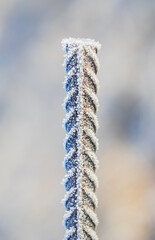Frozen weldable reinforcing steel covered with hoarfrost. Winter simple background