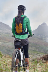Fototapeta premium Woman, mountain bike and fitness in nature trail with vision, ready or idea on adventure with back. Girl, person and start with challenge, race or journey with bicycle on hill workout in Cape Town