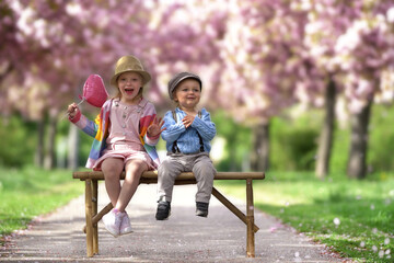 lachende Kinder auf einer Bank im Frühling