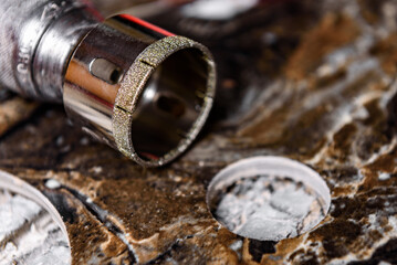 Diamond core drill on black marble tile. 