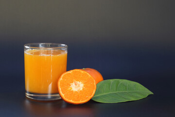 tangerine juice in a glass on dark background