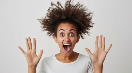 Excited young woman with an afro hairstyle raising hands in joy