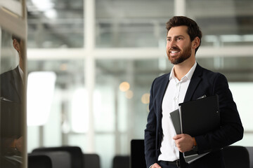 Smiling man with folders in office, space for text. Lawyer, businessman, accountant or manager
