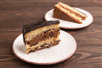 Chocolate biscuit cake with caramel cream on brown wooden. side view