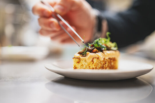 professional chef's hands cooking brioche with salmon mousse in restaurant kitchen