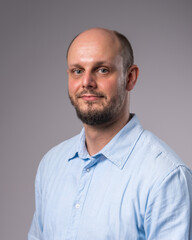 Fototapeta premium Portrait of a 35-year-old man with a beard in a blue shirt. Close-up