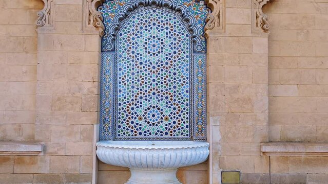 The camera zooms out to show traditional mosaic artworks at Hassan Mosque in Rabat, Morocco