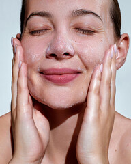 Facial cleansing. Morning skin care routine. Beauty portrait young happy woman  is applying white...