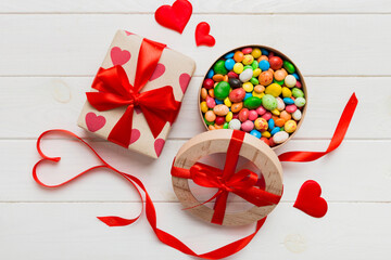 Valentine day composition: sweet candy, with gift boxes with bow and red felt hearts, photo...