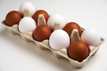 Brown and white eggs in carton on white with clipping path