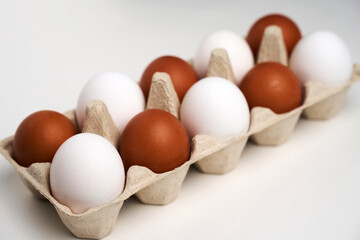 Brown and white eggs in carton on white with clipping path