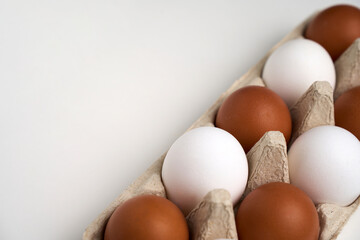 Brown and white eggs in carton on white with clipping path