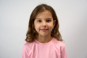 Close-up portrait of a cute child girl in a pink shirt