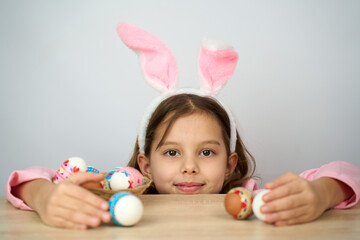Funny happy child girl with easter eggs and bunny ears