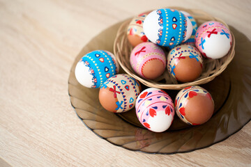 Easter basket with colorful Easter eggs on a wooden table