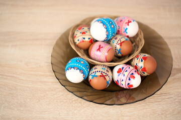 Easter basket with colorful Easter eggs on a wooden table