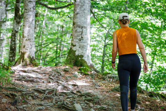 Fitness woman in sportswear walking through the woods