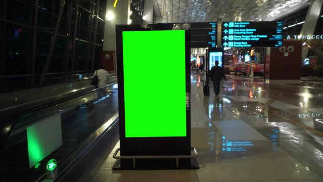 Digital panel green screen inside an airport with people walking