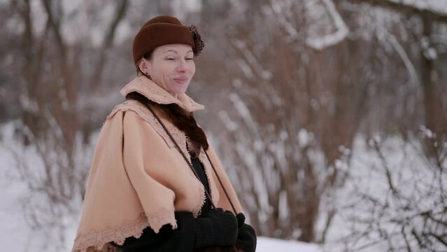 A middle-aged lady in a caftan and hat recalls the beautiful era of the 19th century. Her face is wrapped in a delicate veil of time, slowed down by winter worries.