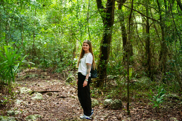 hiker on a path through the dense, shady tropical jungle of the Yucatan