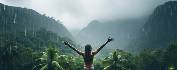 happy woman embracing the warm tropical rain as she swims in an infinity pool, overlooking the lush jungle. - obrazy, fototapety, plakaty