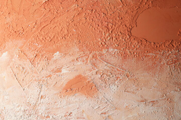 Parete con texture materica dipinta a tempera di colore arancio-beige; spazio per testo