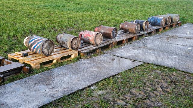 Old milk cans lying in a row. Carbide shooting is a tradition in the Netherlands and usually takes place on New Year's Eve. The goal is to make a loud bang after the carbide gas is ignited