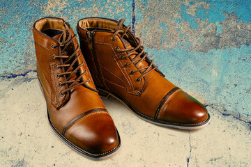 A pair of premium calfskin boots on a stone background. Horizontal shot.