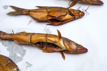 Smoked freshwater zander and common bream fish for home use on white paper..