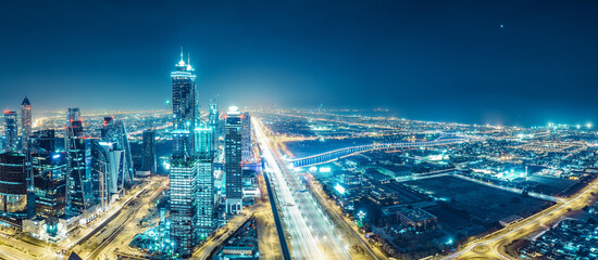 Spectacular urban skyline with colourful city illuminations. Aerial view on highways and skyscrapers of Dubai, United Arab Emirates. - 723722611
