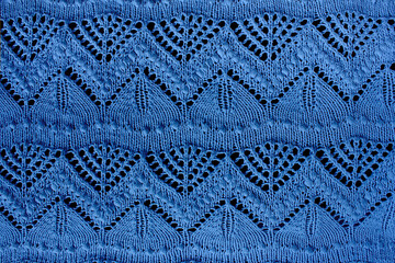Textured blue openwork close-up knitted on needles. Blue patterned background - obrazy, fototapety, plakaty