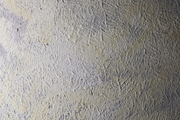 Parete con texture materica dipinta a tempera di colore grigio-giallo; spazio per testo