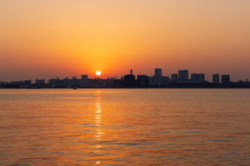 Fototapeta na wymiar ポートアイランドに昇る朝日　神戸市中央区神戸港にて