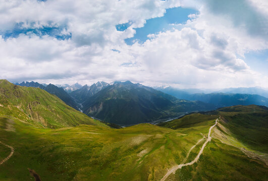 Aerial view at the Koruldi lakes. Green hills, high mountain pastures. Summer day. in the background are the snowy peaks of the Caucasus Mountains. High resolution panorama