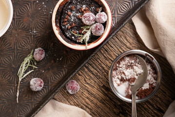 Individual chocolate brownie cups.  Preparing individual serving sizes of brownie treats topped with powdered sugar and mini chocolate chips. Rustic background.