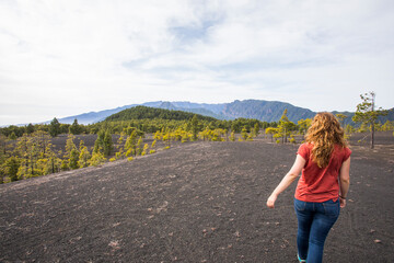 Naklejka premium Young woman and sunset in Llano del Jable, La Palma, Canary islands.