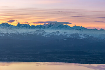 Colourful morning sky with Cirrus clouds above Swiss Alps with lake