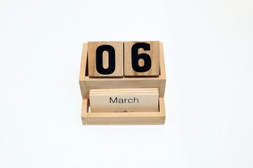 Close up of a wooden perpetual calendar showing the 6th of March. Shot close up isolated on a white...