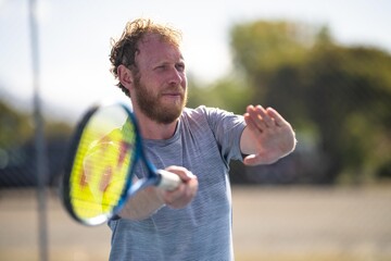 tennis player ready to return serve out in the sun on a tennis court in summer in australia