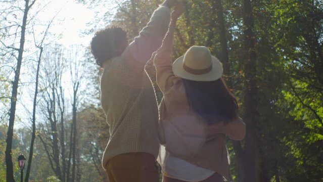 Happy loving multiethnic married couple in love african american man indian woman dancing in park outdoors dance together in sunshine in nature tenderness affectionate family closeness relationship