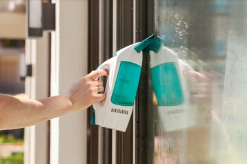 Cleaning Window Glass with Electric Vacuum Cleaner Device. Worker Hand Washes the window of Modern...