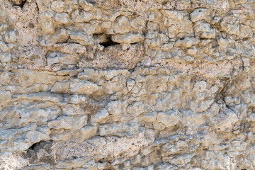 Old fortress wall made of natural stone as a structural background.